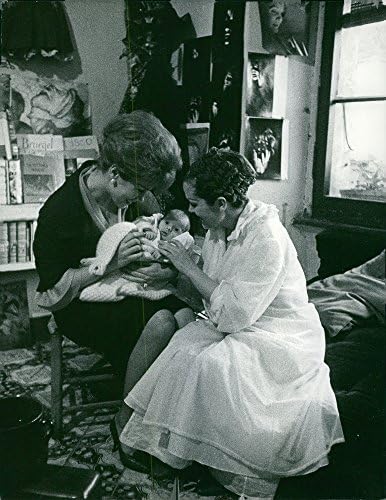 Реколта снимка на Две жени, които играят с новороденото бебе. Снимка е направена на 9 май 1961 година.